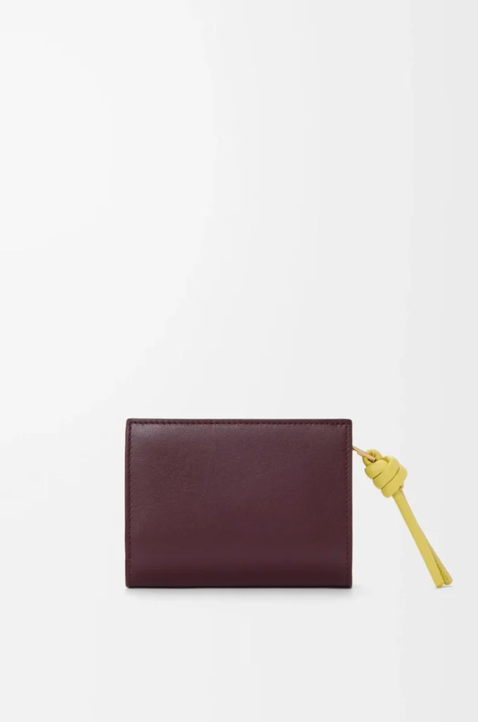 Kompakt plånbok med knut i glänsande nappa kalvskinn Mörk burgundy/Ljus citrin Kompakt plånbok med knut i glänsande nappa kalvskinn Mörk burgundy/Ljus citrin
